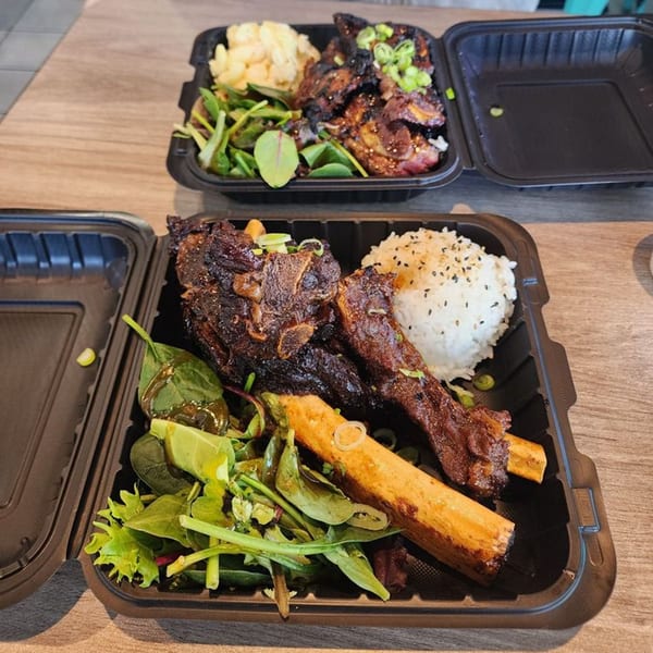Two Big Bros Hawaiian Grill takeout containers with ribs, rice, salad, and potato salad.