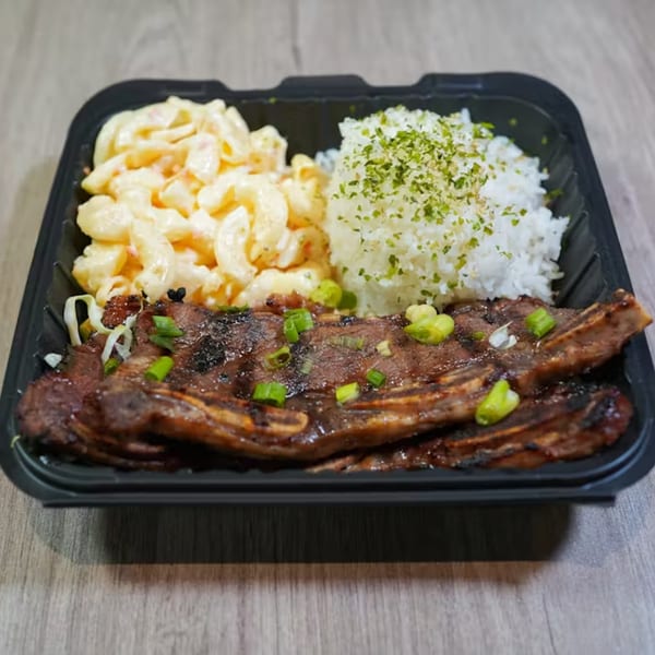 Big Bros Hawaiian Grill's kalbi ribs plate with macaroni salad and rice, garnished with green onions.