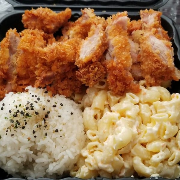 Crispy fried chicken katsu, white rice with furikake, and creamy macaroni salad in a black takeout container.